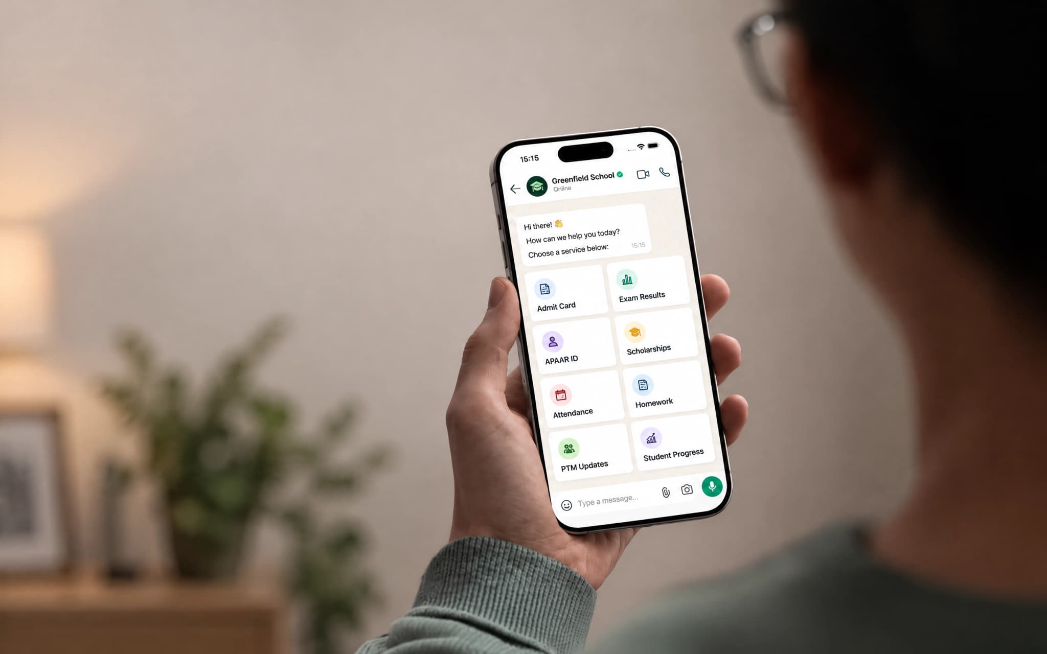 A person holding a phone showing the Greenfield School WhatsApp chat with education services